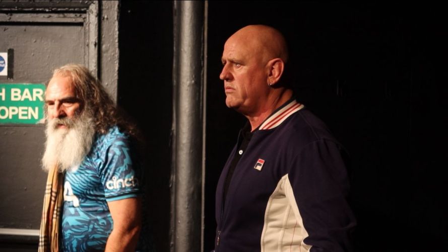 Standing on the left in a blue multi-coloured football shirt and Burberry style checked scarf Daisy Boy (played by Jud Charlton) and standing on the right Danny Boy (played by Francis Saunders) in a blue and cream Fila jacket.