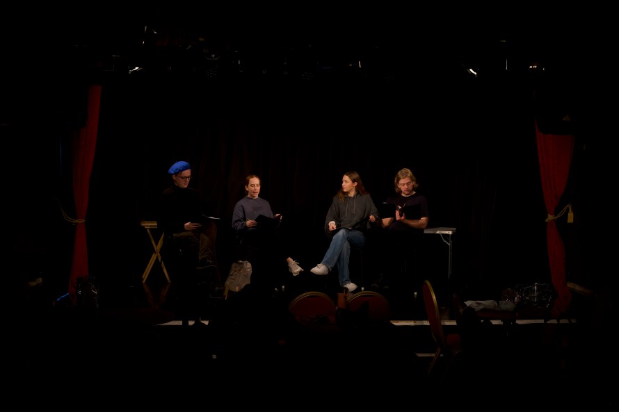Four actors dressed in casual clothes doing a runthrough of a script. Left to right - Nathaniel in blue beret (played by Jake O'Hare), Sadie (played by Rebekah Nicol), Olivia (played by Lucy Blunt) and Tom (played by George Almond).