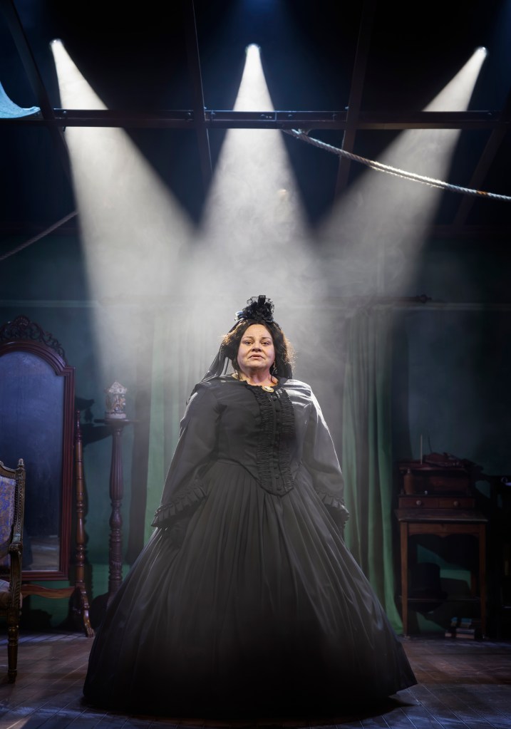 Mary Lincoln (Keala Settle) standing spotlit in dark Victorian mourning garb.
